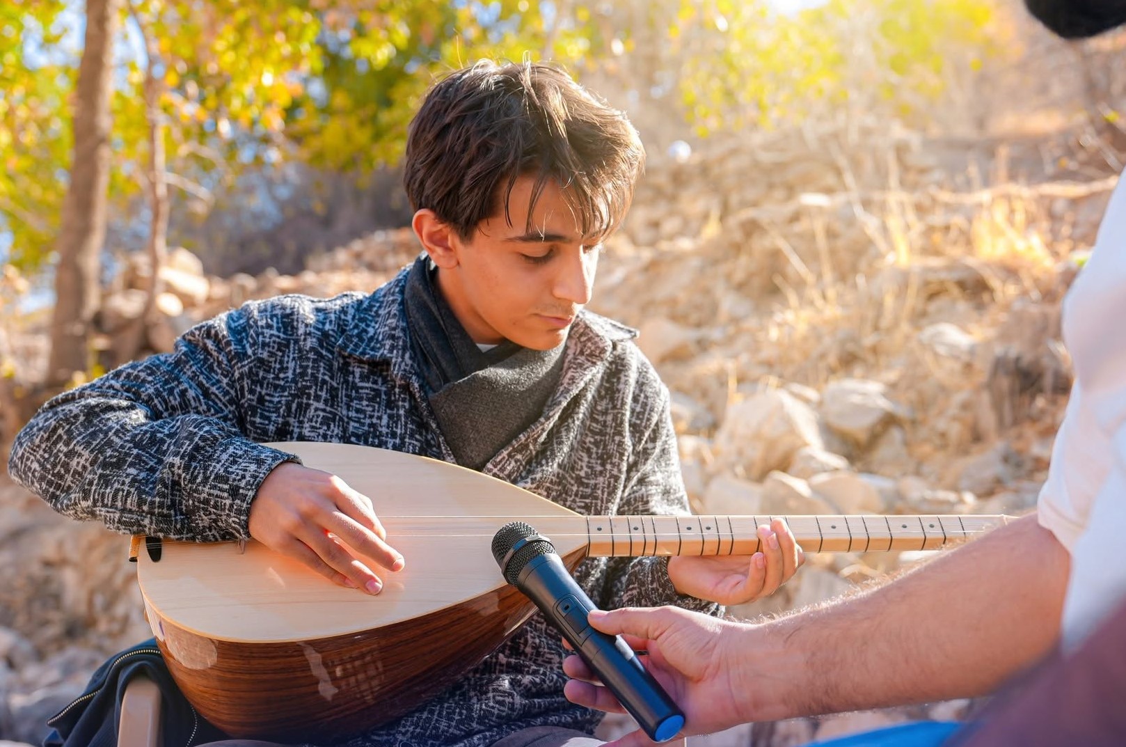 A student playing the ukulele on stage during the boys spring festival performance
