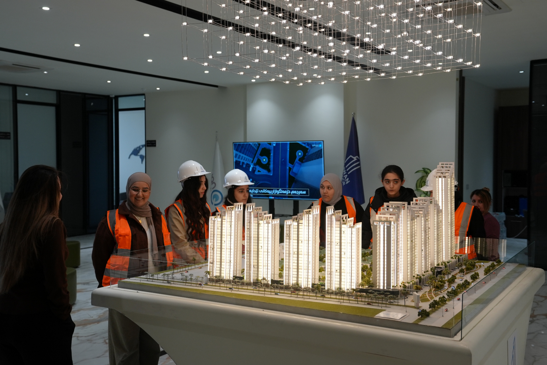 Students wearing hard hats and trying construction tools during a hands-on careers workshop