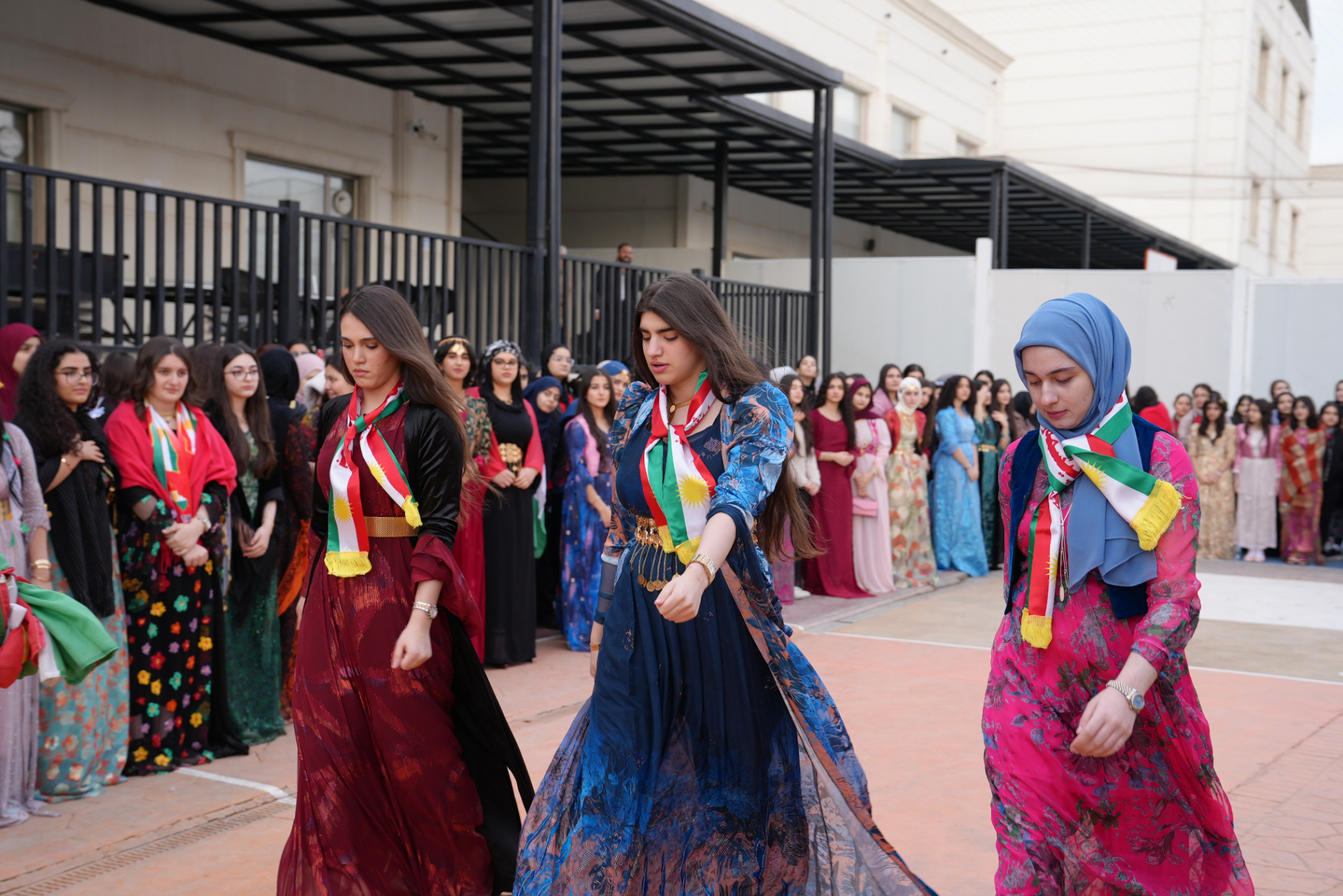 Girls holding flags during the national flag day assembly at the compound