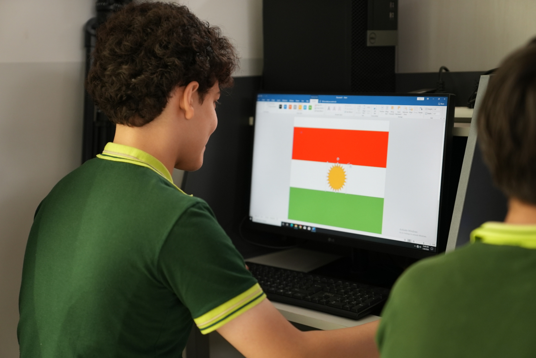 Students designing a digital Kurdistan flag on computers in the ICT lesson